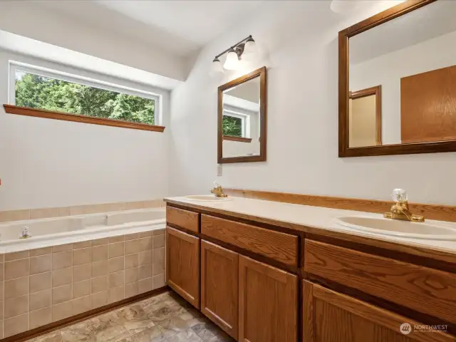 Primary bath with double sinks, soaking tub with shower and toilet in separate space.