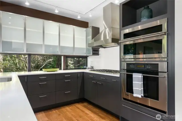 Love the mid-century "ribbon windows" creating a window backsplash with Quartz countertops. This kitchen was designed for entertaining with lots of counter space, coffee bar, wet bar, and pantry.