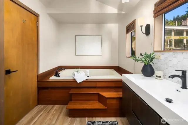 The bathroom includes jetted soaking tub, shower, separate toilet and skylight.
