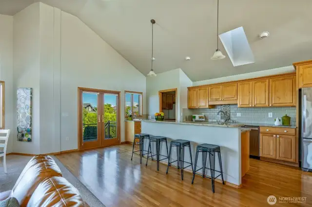 Pull up a stool and chat while dinner simmers—this inviting kitchen with breakfast bar is perfect for everyday connection and easy entertaining. French doors invite you out to the deck, blending indoor comfort with outdoor living.