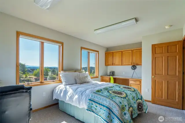 This versatile space offers a built-in desk and upper cabinets—ideal for working from home, crafting, or study. Large windows invite in natural light and scenic views to keep you inspired.