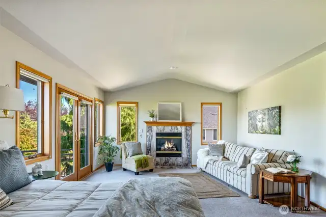 Vaulted ceilings and walls of windows give this generously sized Primary Suite an airy, restful feel. Whether curling up by the fire or enjoying your private sitting area, this space offers true luxury and relaxation.