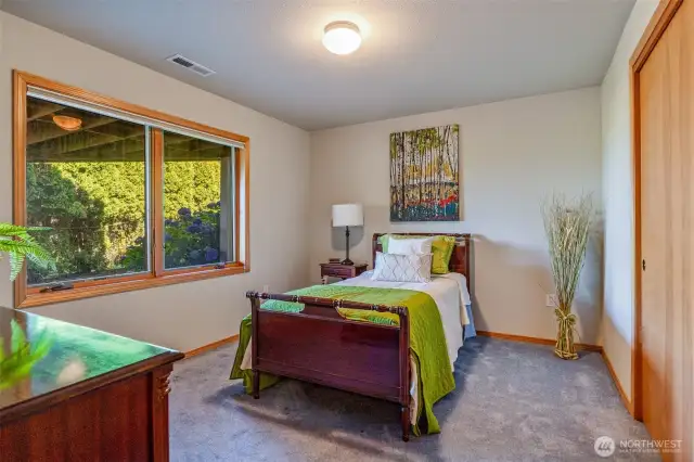 Tucked quietly on the lower level, this secondary bedroom offers peaceful garden views, generous closet space, and a cozy retreat-like feel.
