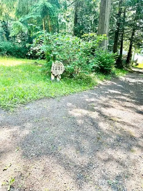This is the gravel road/drive to the left of the property you'll go down for access. The 1231 sign is the NEIGHBORS marker sign (NFS)