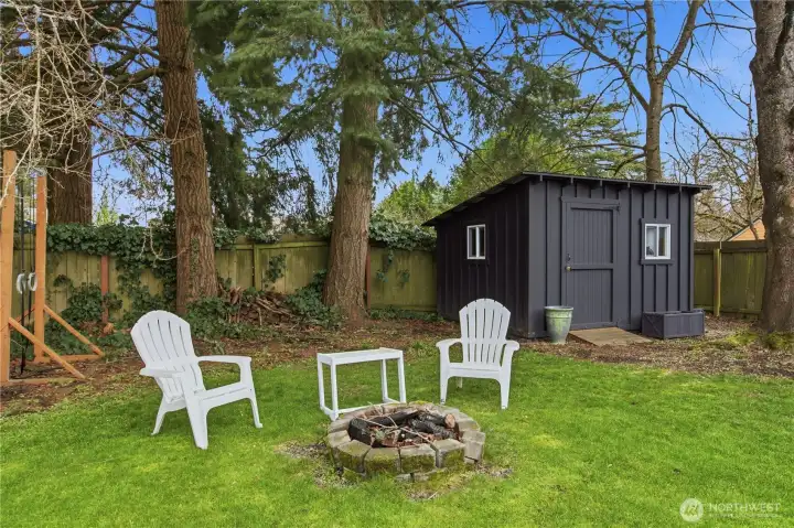 Lovely firepit area and handy storage shed in the backyard