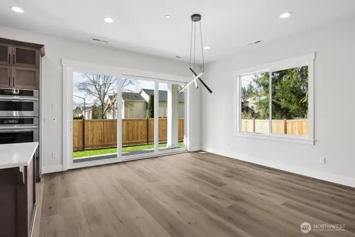Large dining space that looks out to covered patio and yard. Huge double sliders combine indoor/outdoor spaces beautifully.