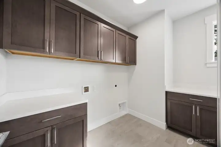 second floor laundry room with extra storage, sink, and counterspace.