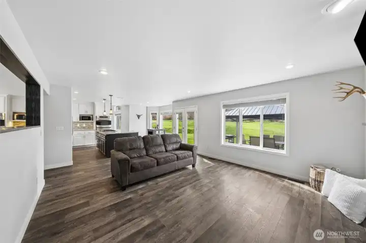 Oversized family room offers lots of different seating options- LVP flooring, large windows, & open concept living.