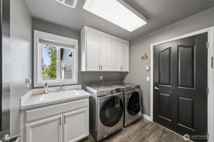Main level laundry area located just off the attached 3 + car garage. LVP flooring, Culligan water purification system throughout this home + plenty of storage & deep sink!