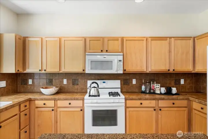 Kitchen offers an abundance of maple cabinetry, providing exceptional storage and organization. A gas range makes meal preparation a pleasure and the generous workspace is ideal for both everyday cooking and entertaining.