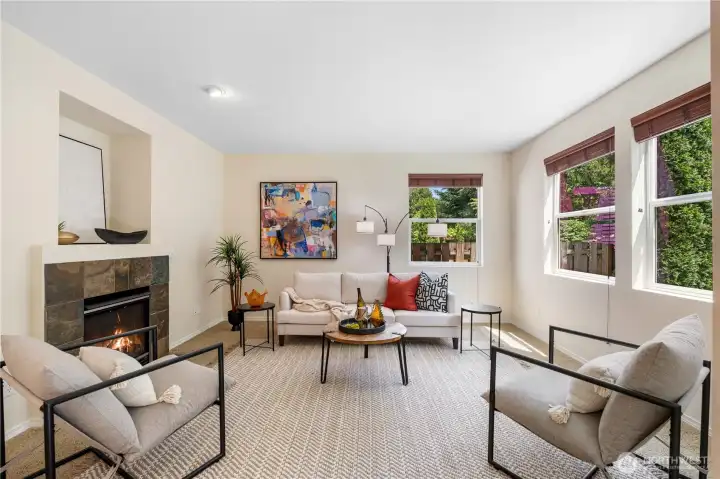 Spacious family room showcases a gas fireplace with a convenient TV niche above and is flooded with natural light,enhancing the warm and airy feel of the space.