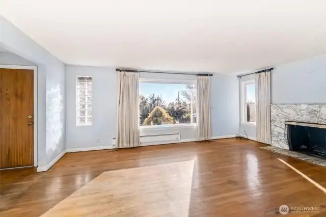 Living room features large windows and a wood burning fireplace.