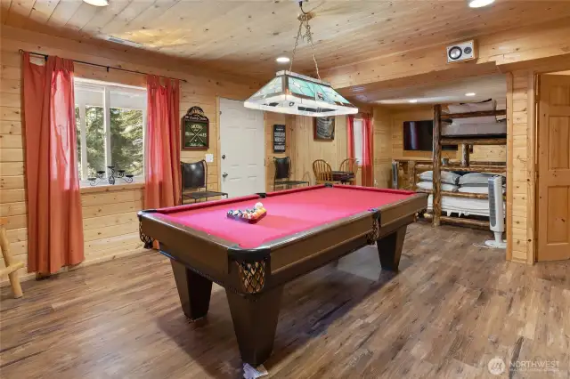 This rec room is in the daylight basement of this home. It features a pool table and provides access to the front patio hot tub and outdoor entertainment area!