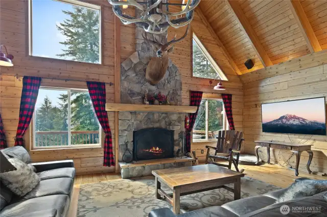 The stunning river rock fireplace is 2 stories high with windows flanking. Imagine this view with the snow coming down!