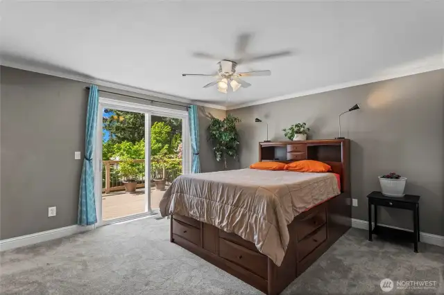 The primary suite boasts luxurious new carpet and padding, crown molding, a spacious closet, and a sliding door leading to the expansive back deck. Picture yourself waking up to a picturesque view.