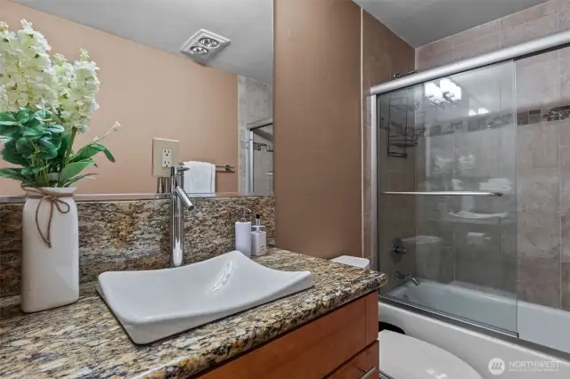 The Main bathroom is in a class all it own.  This full bath also has glass shower doors, heated tile flooring, slab granite countertops, a lovely, top-mount sink, AND a combo washer/dryer!