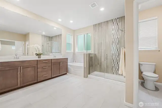 The Primary Bath  features custom tile, quartz counters and a frameless walk-in shower.