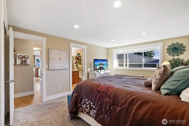 Your primary bedroom has a huge window, cozy carpet and a private bath