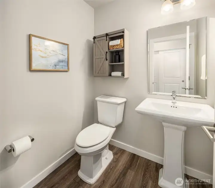 Half bath between the Great Room and garage entry. Opposite from it is another coat closet.
