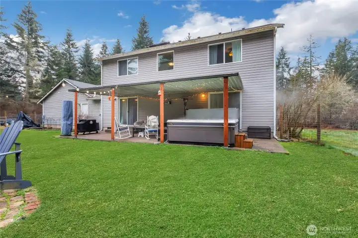 Large back patio and covered hot tub area.   Hot tub included. Lawn /Yard digitally enhanced