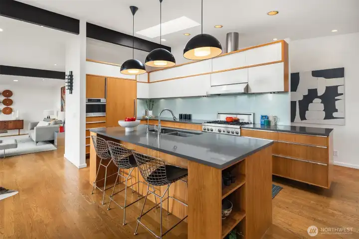 Difficult to believe this kitchen remodel was done in 2010, but it's true.  Testament to the fact that simple/understated classic design is always timeless.  Custom walnut cabinetry is topped with sleek gray quartz.   White-painted sliding uppers are framed in walnut and seem to float above the sea-glass-inspired backsplash.