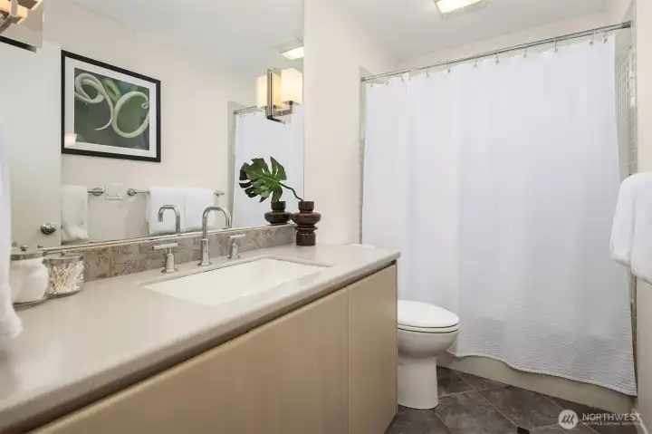 A large glass-block window welcomes north-facing natural light into the main-floor full bath.