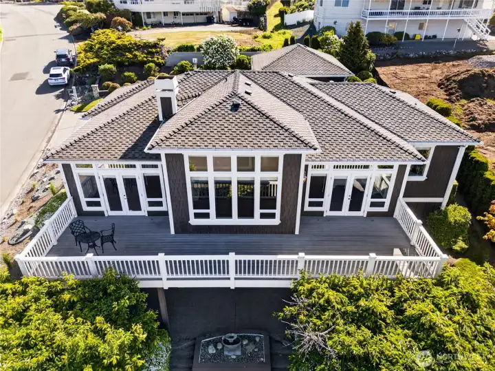 Large deck for entertaining and below, a patio with a water feature. That new roof was installed in 2022.