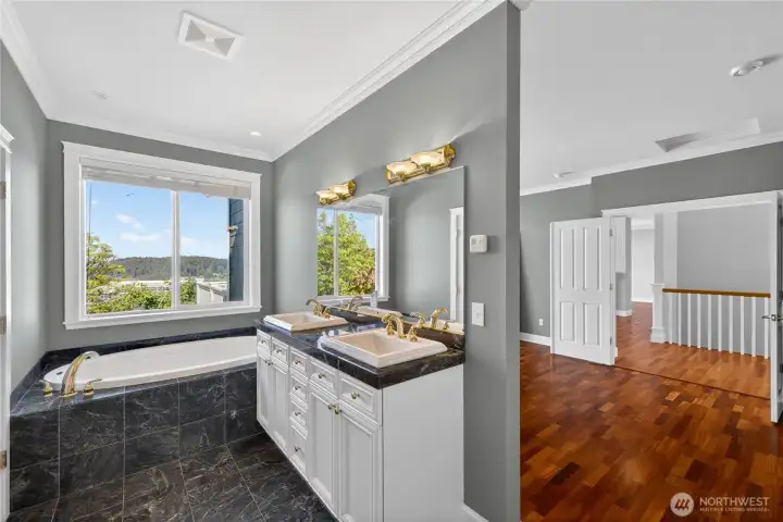 The primary bathroom features marble floors and countertops with a stunning double-sink vanity.