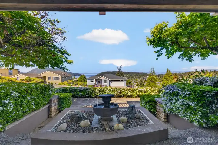 Outside the lower level living room is a bronze water feature and secluded patio.