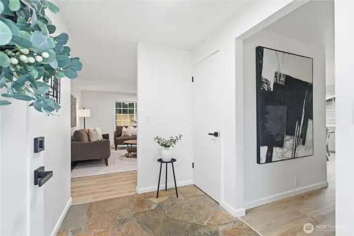 Stone-tile entry flows seamlessly into wood-look flooring, offering a clean, modern transition into the main living areas.