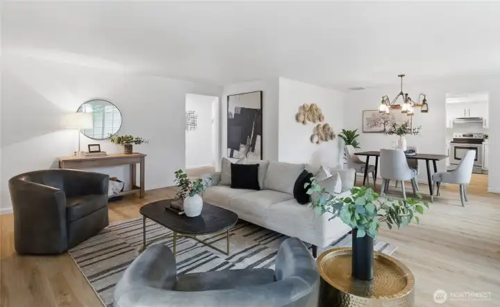 Open-concept layout with clear sightlines from the living room through to the dining area and kitchen, all unified by warm wood-look flooring.