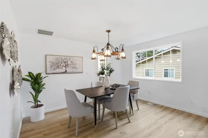 Alternate angle showcases the room's generous proportions, large grid window, and easy flow to adjacent living areas.