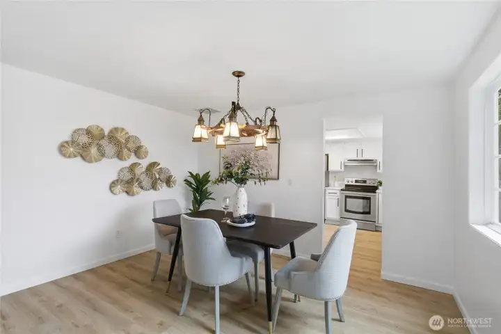 Clean, bright dining space with a decorative chandelier and pass-through view into the remodeled kitchen — ideal for everyday meals and entertaining.