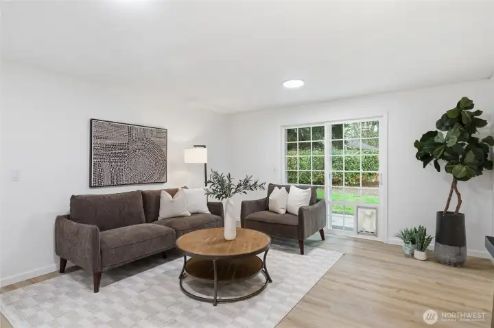 Comfortable secondary living space with wood-look floors, sliding glass door to the backyard, and a relaxed layout perfect for everyday use.