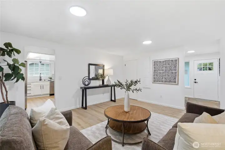 Wide view captures the full depth of the space, including sightlines to the kitchen and foyer entry — a true hub of the home.