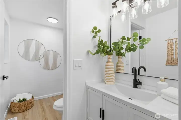 Updated en suite bath featuring a white shaker vanity, quartz countertop, black hardware, and modern globe lighting.