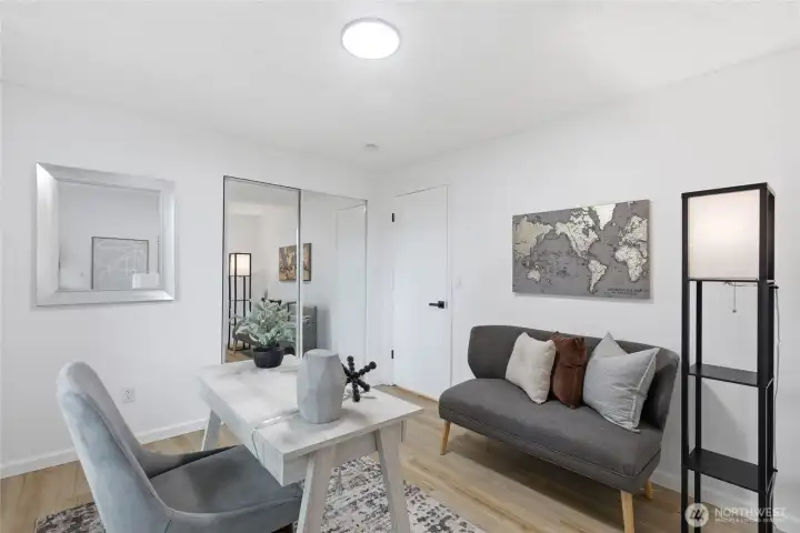 Versatile room with mirrored closet doors and wood-look floors, ideal as a bedroom, home office, or flex space.