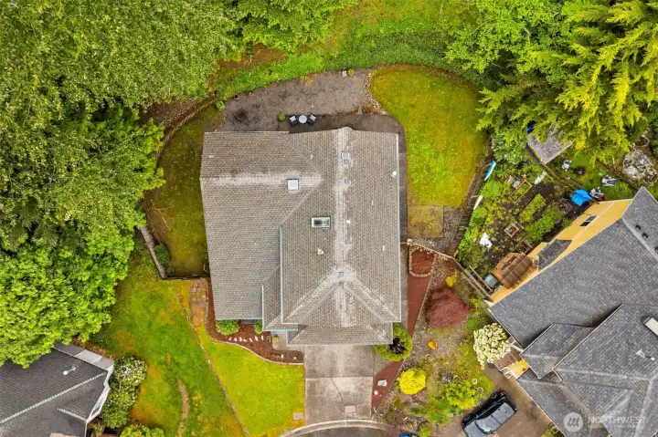 Situated on a pie-shaped lot with a forested backdrop, the property provides added privacy and a peaceful setting.