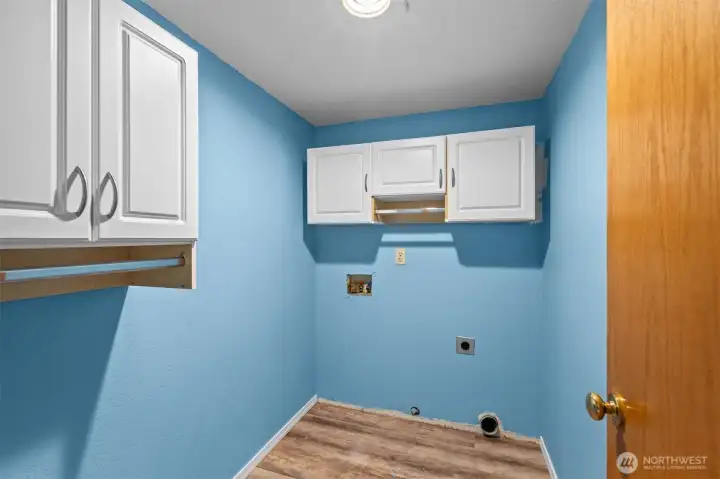 Full size laundry room with storage and hang dry bars.
