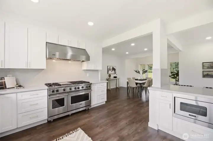 Quartz countertops, custom cabinetry, open shelving, oversized window, & undermount sink.