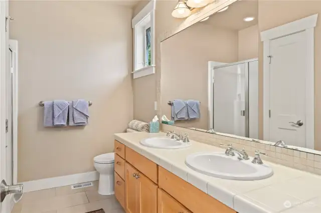 Primary bathroom has double sinks and a step-in shower.