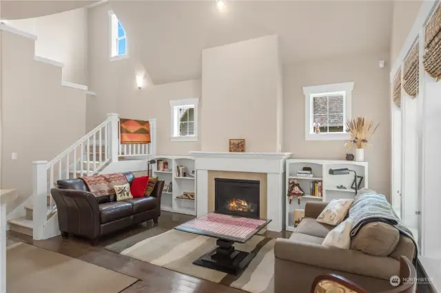 Main living room has very high ceilings, a propane fireplace and hardwood floors.