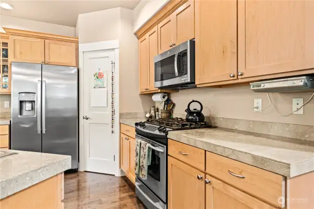 Propane range, beautiful countertops. Door next to the nearly new fridge is a pantry for more storage.