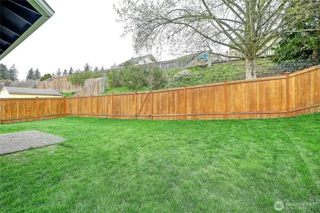 Gorgeous fully fenced yard which features solar lights every 8-10'  section around the entire yard.  There is a gate along the back that opens up to the remaining parcel boundary line at the top of the slope.  This parcel boundary line goes up to the neighbor's fence. Nice buffer.