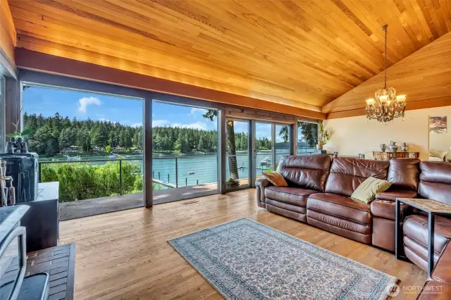Great room with a wall of windows showcasing this amazing waterfront residence