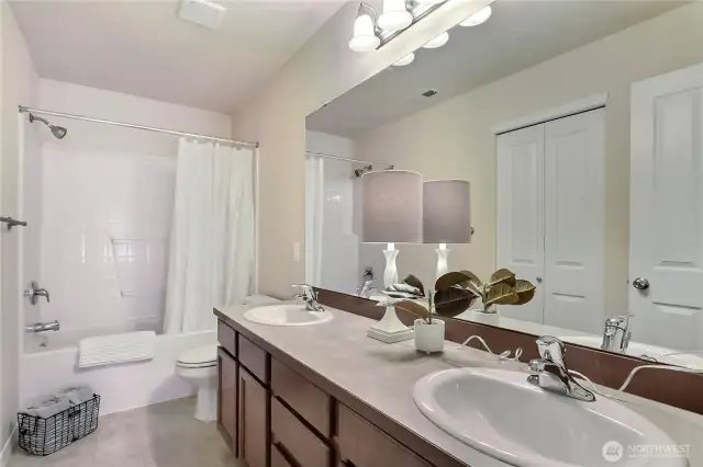 The upstairs main hall bath is bright and modern, featuring clean lines and a double vanity for added convenience. Its fresh design creates a welcoming space that’s perfect for busy mornings or relaxing evenings. Plenty of light and thoughtful details make this bathroom both stylish and functional. It’s a great shared space for family or guests.