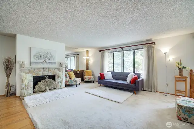 Light-filled spacious living room boasts wood-burning fireplace and invites comfortable relaxation