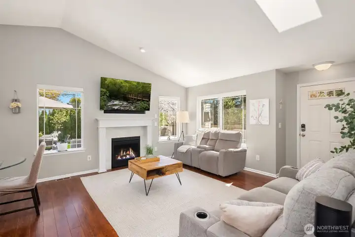 Expansive windows and an inviting gas fireplace anchor complete the welcoming feeling of this light filled living room
