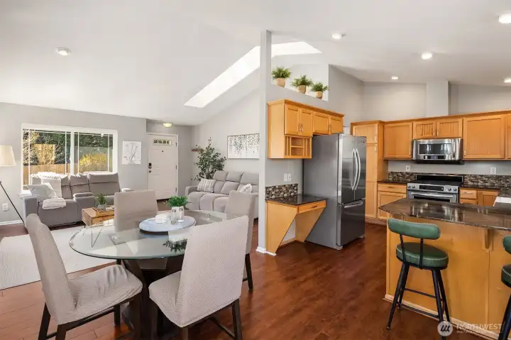 The open floor and cathedral ceilings make this dining and living room and the kitchen feel functional and inviting