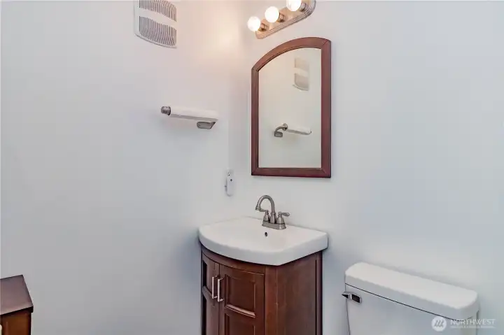 Downstairs powder room. Bathroom updated with new vanity, sink, hardware, mirror, toilet and light fixture.